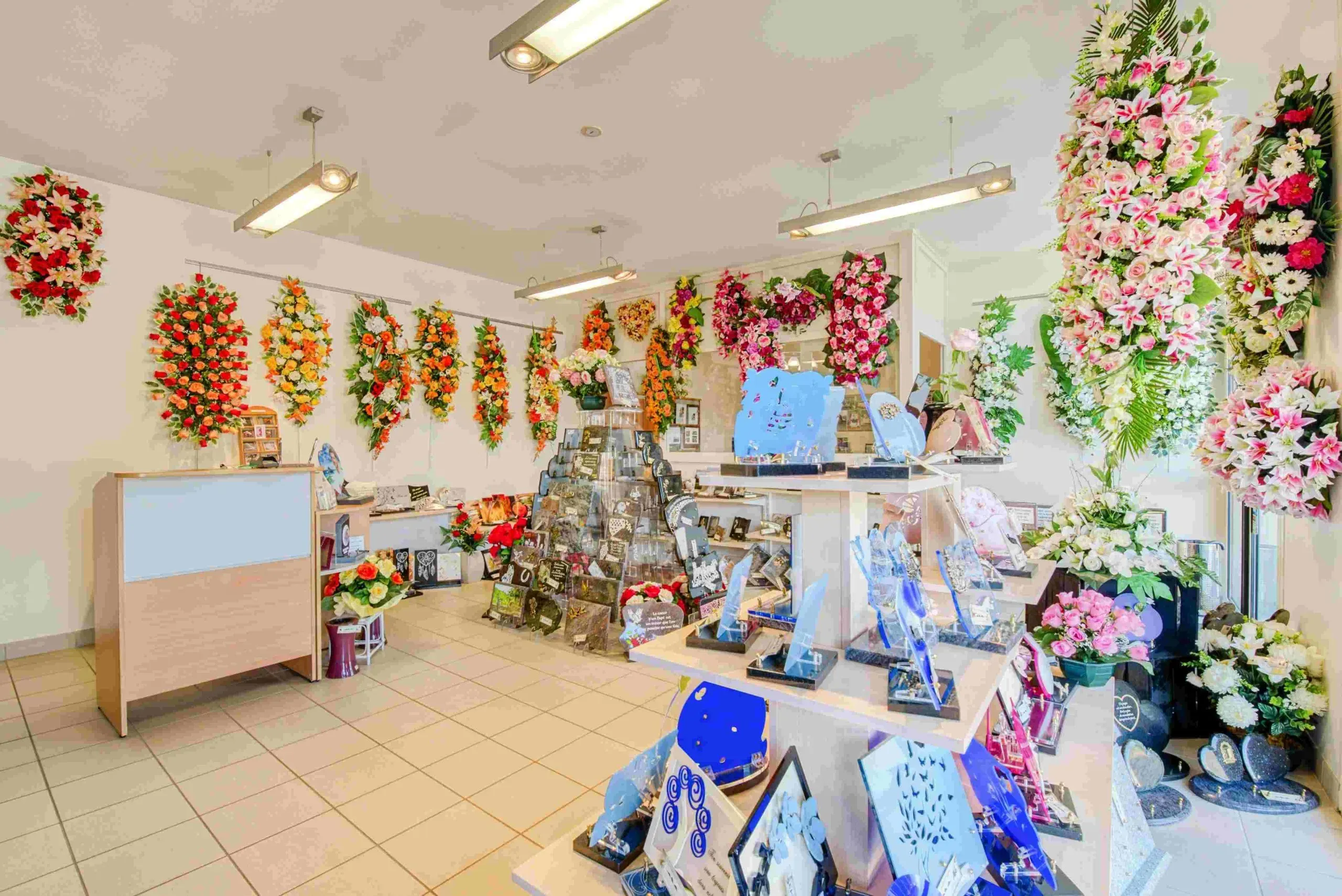 Magasin d'articles funéraires proposant plaques commémoratives et fleurs.